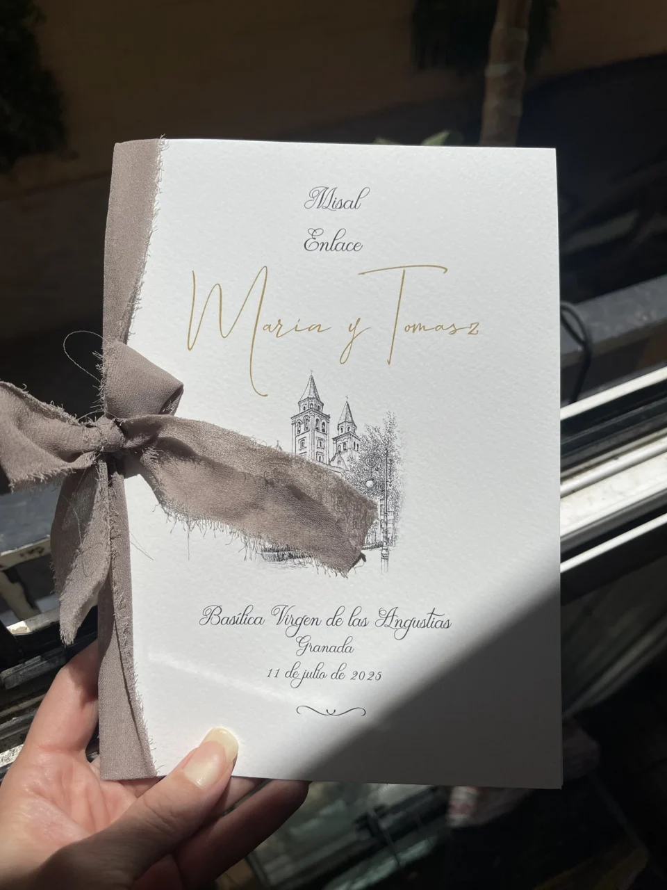 Portada del misal de María y Tomasz, con una ilustración de la Basílica de las Angustias y un lazo de tela