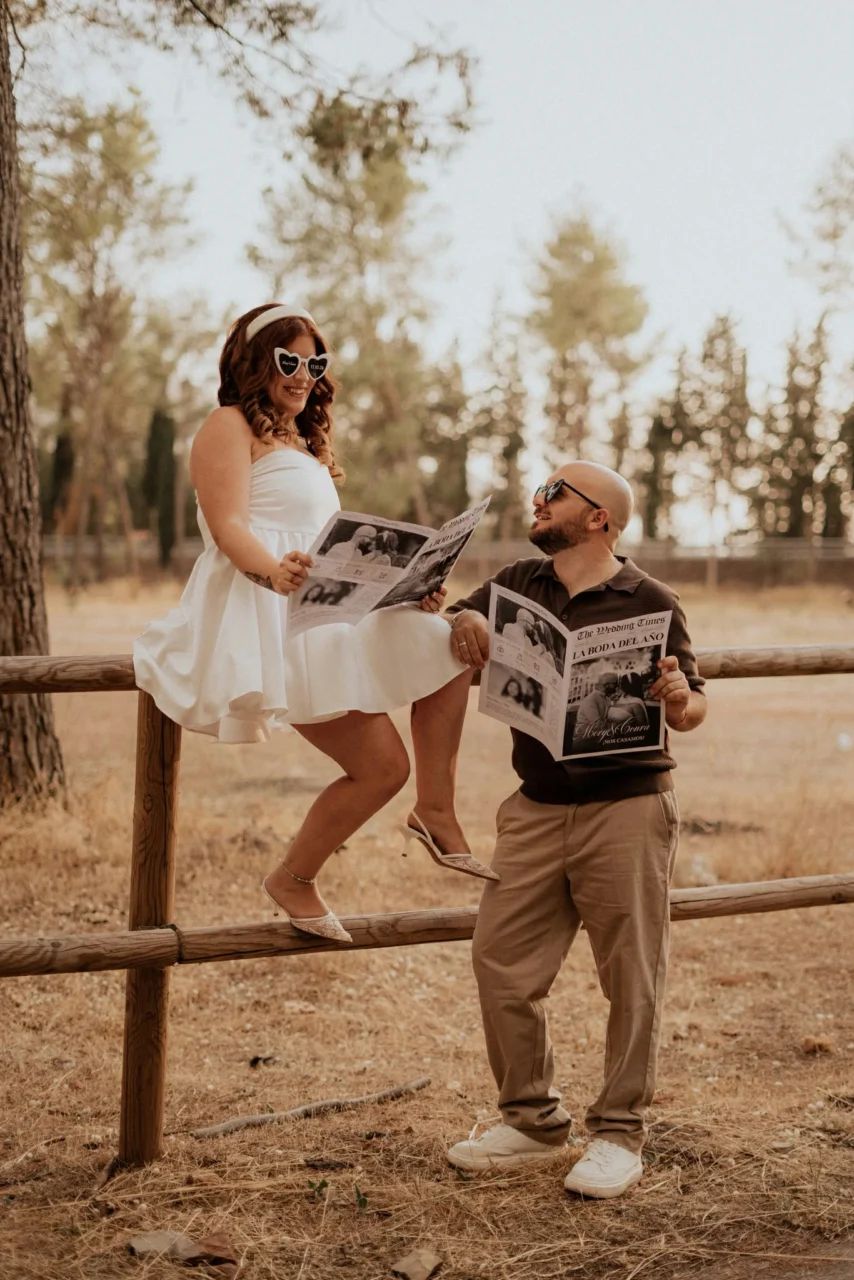 Pareja leyendo su periódico de boda personalizado al aire libre
