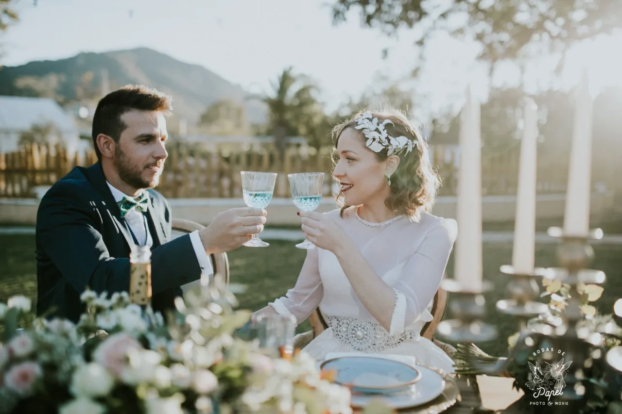 Pareja brindando durante una sesión editorial de boda; fotografía Bodas de Papel